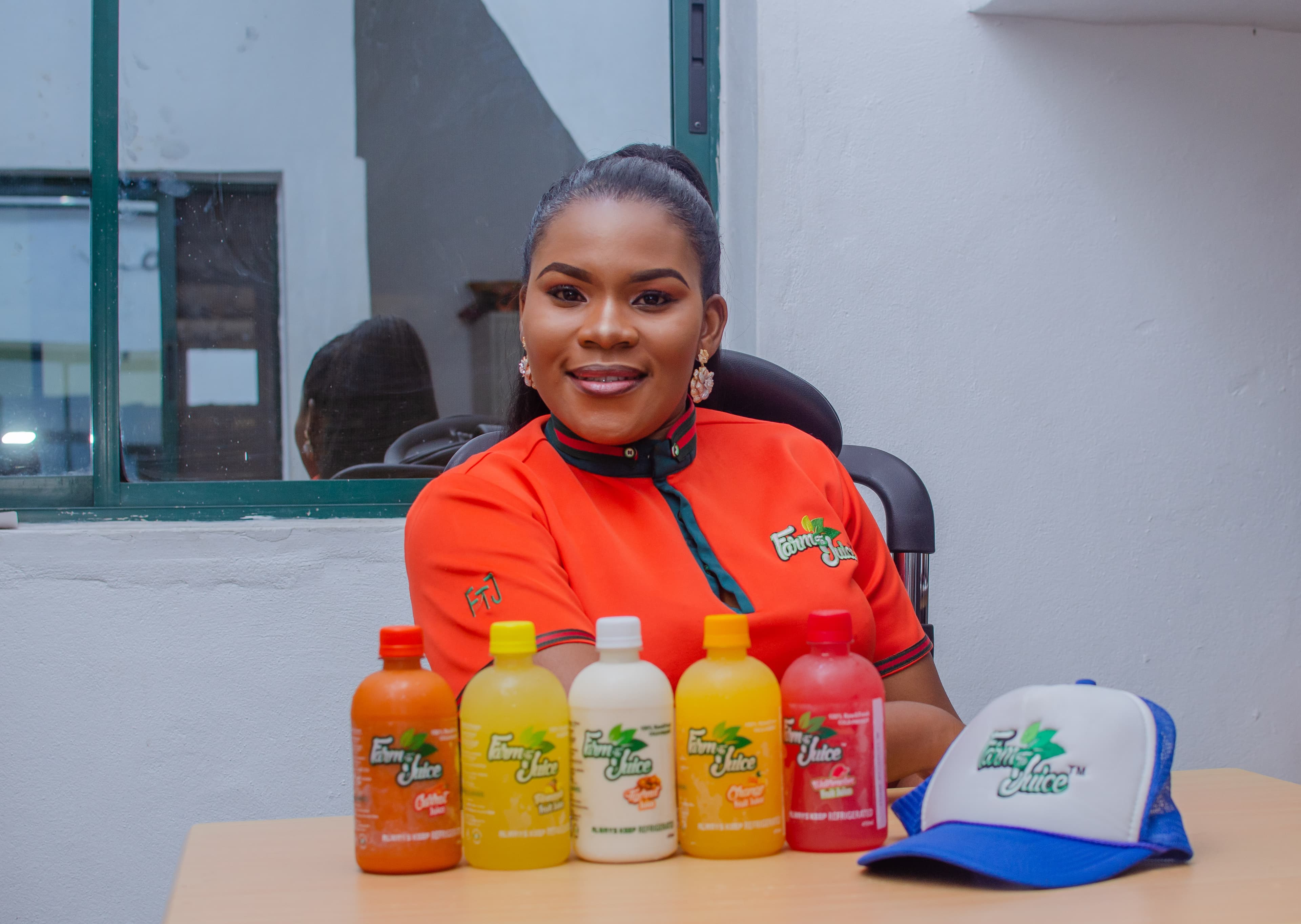 A young Nigerian entrepreneur presenting bottled fruit juice